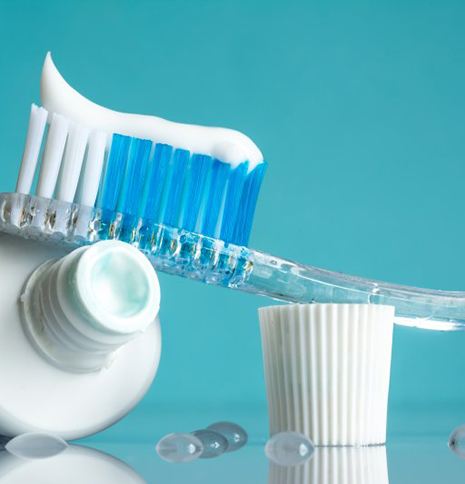 Toothbrush resting on a tube of toothpaste